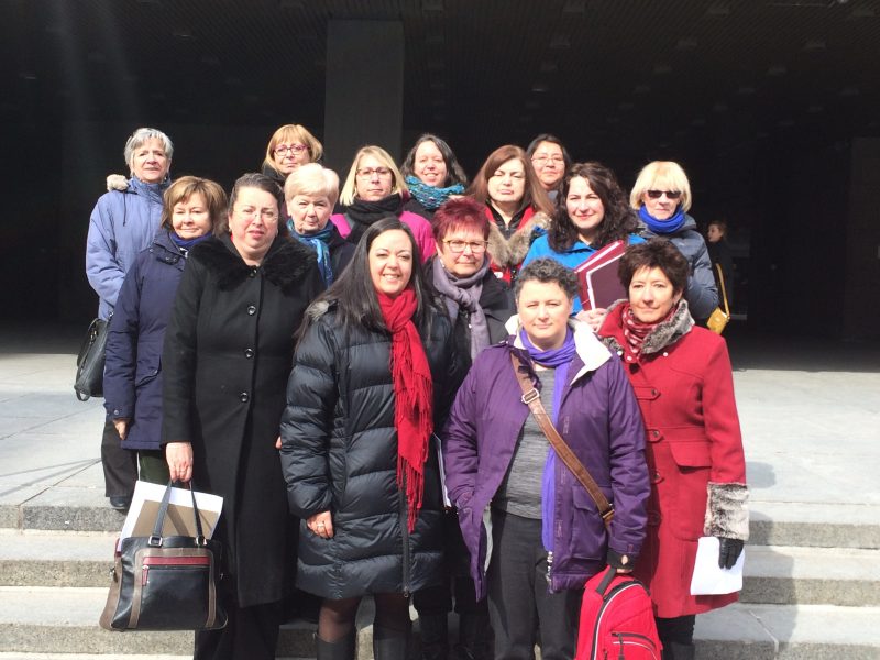 Des militantes féministes se tiennent debout l'une à côté de l'autre.