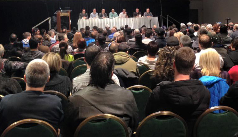 Une foule de personnes sont assises dans une salle