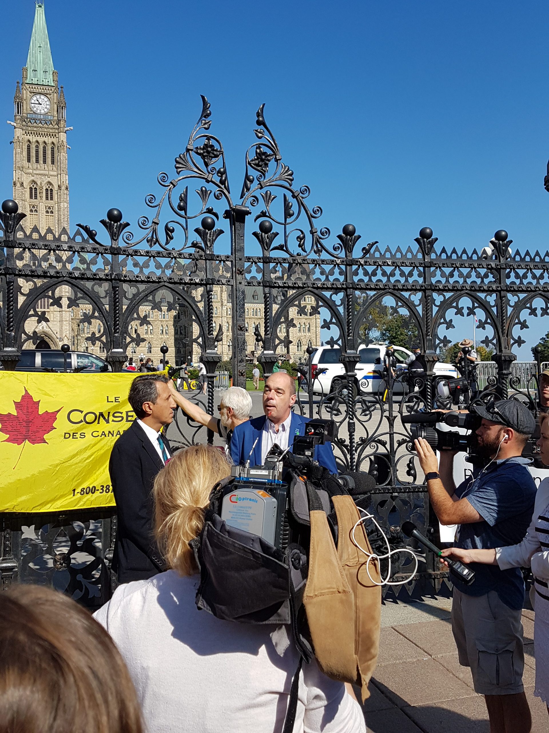 Luc Vachon s'adressant à une foule de journalistes devant le Parlement d'Ottawa.