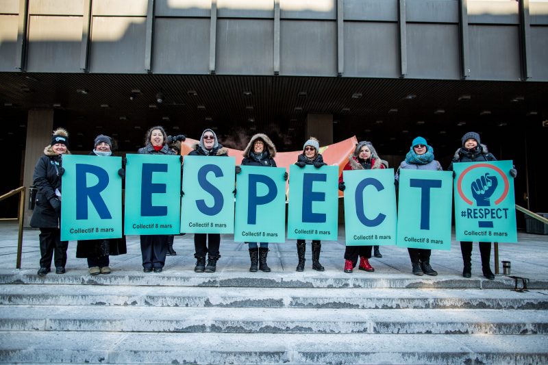 Des femmes debouts tiennent des affiches et forment le mot respect
