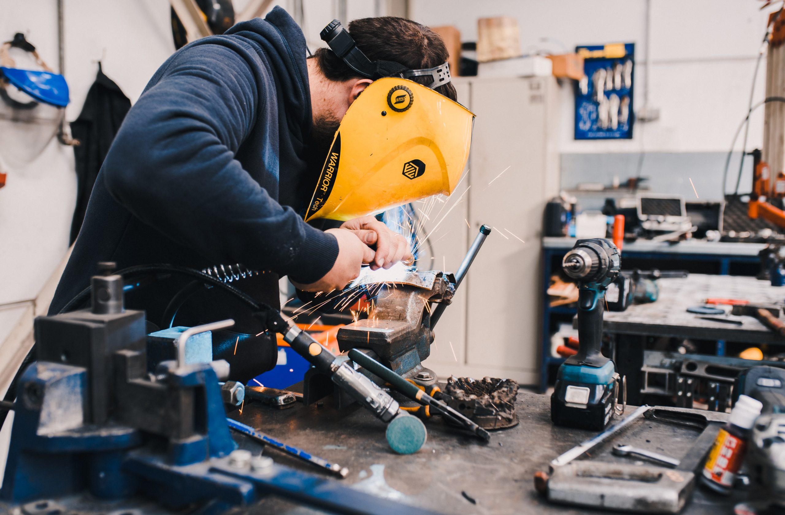 homme travaillant une pièce de metal