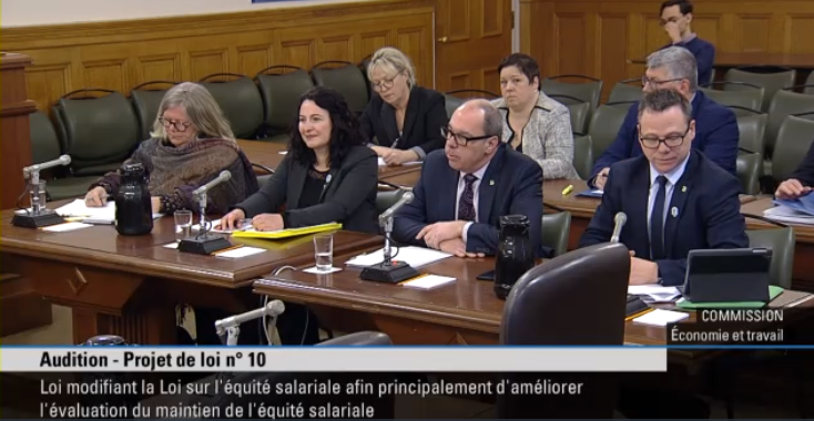 Des personnes sont assises à une table à l'assemblée nationale