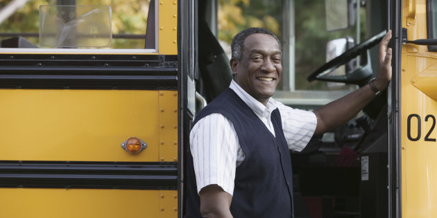 Un homme debout devant un autobus