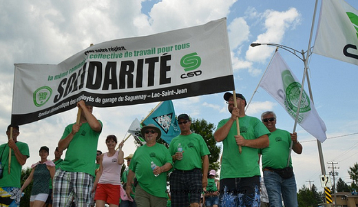 Manifestants du SDEG tenant une pancarte SOLIDARITÉ et des chandails verts à l'effigie de la CSD.