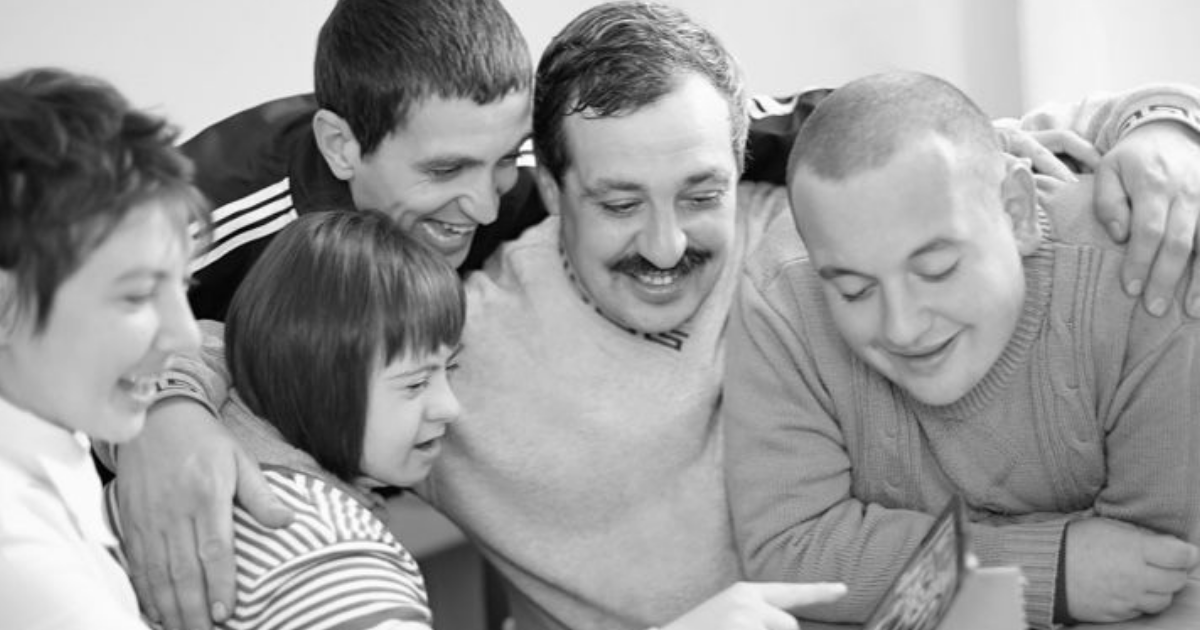 Photo en noir et blanc de plusieurs jeunes regardant un écran.