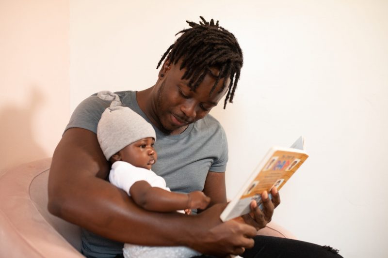 Papa lisant un livre à son bébé.