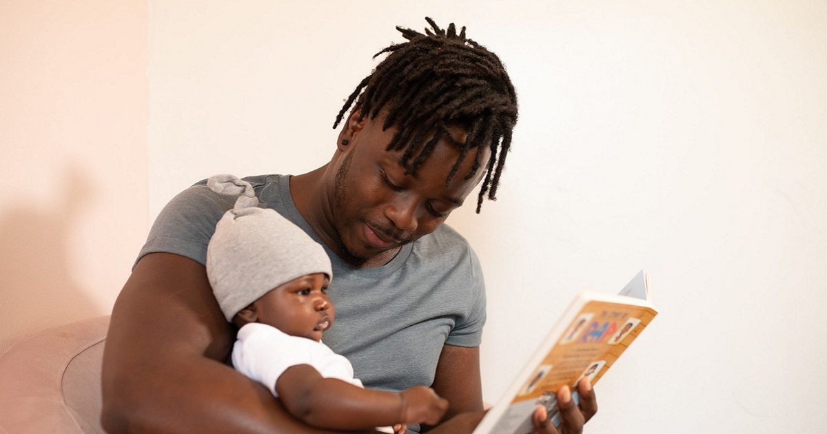 Papa lisant un livre à son bébé.